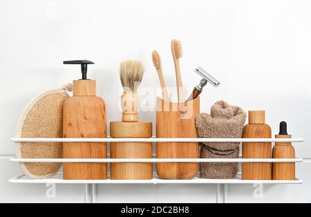 Gros plan des bouteilles en bois naturel de produits cosmétiques de beauté, serviettes, accessoires d'hygiène et de toilettage sur étagère de bain sur fond blanc, bas an Banque D'Images