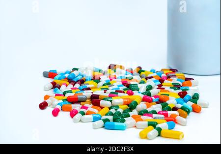 Capsules colorées près d'une bouteille de médicament en plastique. Pilules de capsule multicolores sur table blanche. Pharmacie produits de pharmacie. Industrie pharmaceutique. Banque D'Images