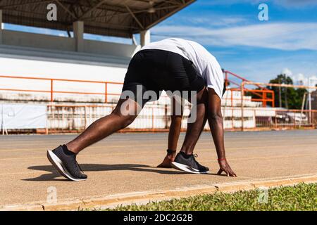 Asiatique jeune athlète coureur de sport noir homme actif prêt à commencer l'entraînement de course à l'extérieur sur le tapis roulant pour un pas en avant, exercice sain Banque D'Images