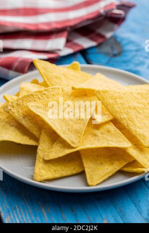 Croustilles de tortilla salées sur une assiette de table bleue. Banque D'Images