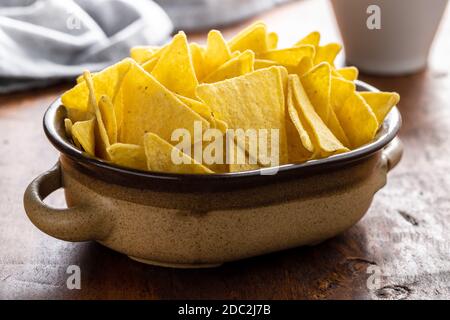 Croustilles tortilla salées dans un bol sur une table en bois. Banque D'Images