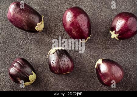 Aubergines fraîches sur fond noir plat Banque D'Images