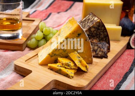 Fromages britanniques et irlandais, assiette de dégustation avec shropshire bleu, fromage de portier brun et cheddar fumé Banque D'Images