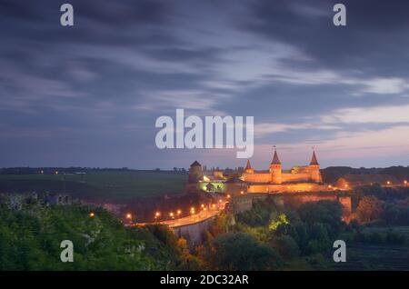 Paysage de nuit avec une route menant au vieux château. Illumination dans un bâtiment historique. Site historique. Vieille ville de Kamenetz-Podolsk, Ukraine, Banque D'Images