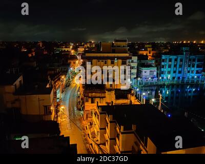 Image d'une vue de nuit sur une ville avec une rue incurvée et des lumières de rue. Banque D'Images