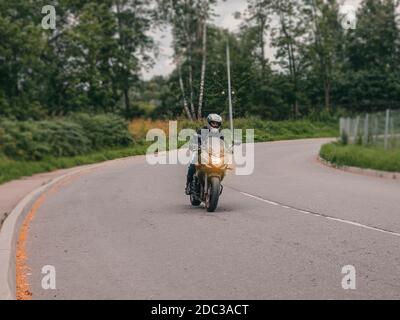 Un motocycliste dans un flou de circulation sur un virage dans la route. Mise au point douce. Banque D'Images