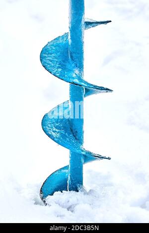 Tarière à glace manuelle utilisée pour la pêche sous la glace. Vis métallique bleue. Percer. Passe-temps, pêche d'hiver sur le lac enneigé Banque D'Images