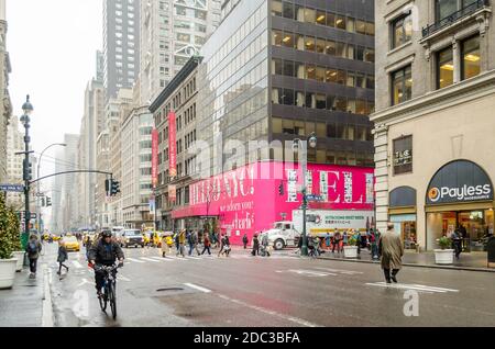 Taxis jaunes et autres véhicules attendant que les piétons croissent la route à Manhattan. Un homme avec un vélo passe. New York, États-Unis Banque D'Images