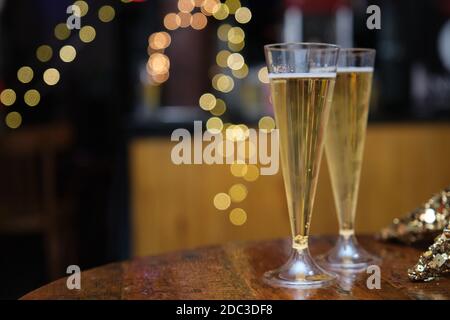 Verres de champagne sur une table, lumières arrière-plan flou. Concept de fête de Noël. Banque D'Images