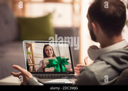 Célébration et vacances pendant la quarantaine concept. Vos amis ou votre famille dépaqueter des cadeaux tout en parlant par appel vidéo. Soyez heureux, gai, sincère. Concept de la nouvelle année, technologies, émotions. Banque D'Images