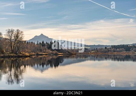 Belle femme âgée avec vélo électrique de montagne appréciant la vue sur le lac automnal Gruentensee dans les alpes d'Allgaeu près de Nesselwang, Alpes bavaroises, Ger Banque D'Images