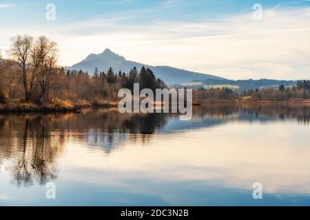 Belle femme âgée avec vélo électrique de montagne appréciant la vue sur le lac automnal Gruentensee dans les alpes d'Allgaeu près de Nesselwang, Alpes bavaroises, Ger Banque D'Images