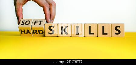 Compétences difficiles contre compétences non techniques. La main fait basculer les cubes et change l'expression « compétences difficiles » en « compétences générales » ou vice versa. Belle table jaune, blanc Banque D'Images