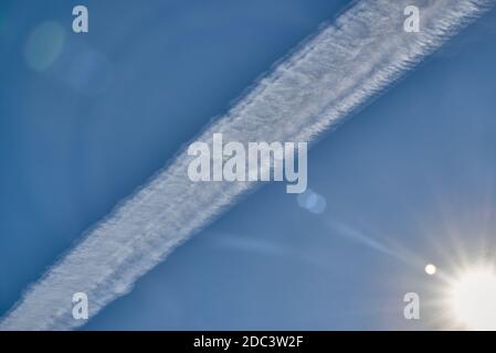 Un seul avion vole à travers le ciel bleu. Jet Trail sur ciel bleu. Contrail sur un ciel bleu. Banque D'Images