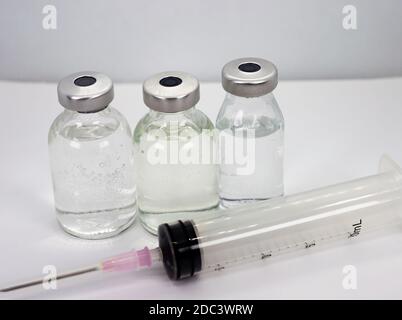 Flacons de vaccin et seringue sur fond blanc Banque D'Images