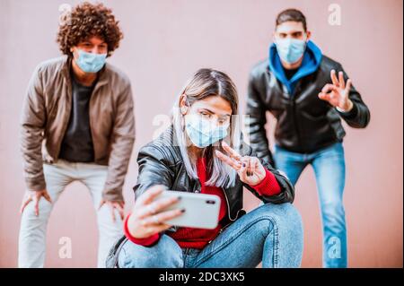 Jeunes amis heureux prenant un selfie dans la rue portant Masques de protection du visage - concept d'adolescents avec sécurité de protection mesures Banque D'Images