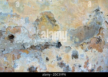 Ancienne texture d'arrière-plan de mur peint abîmé. Mur en plâtre léger et pelé avec des flocons de peinture qui tombent Banque D'Images