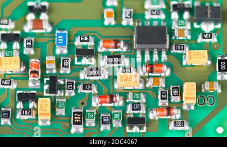 Gros plan des composants électroniques à semi-conducteurs. Carte de circuit imprimé verte. Technologie de montage en surface de résistances, transistors, diodes ou condensateurs. Banque D'Images