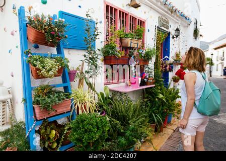 Un touriste regarde la façade d'une maison ornée de pots de fleurs. Benalmádena, Málaga, Costa del sol, Andalousie, Espagne, Europe Banque D'Images