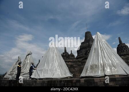 Les agents de conservation du temple de Borobudur enveloppent plusieurs stupas en utilisant la bâche. L'emballage a été effectué au 8ème étage et dans le 1er hall du temple situé à Magelang Central Java, Indonésie. L'augmentation du statut du Mont Merapi à alerte ou niveau 3 (de 4 niveaux existants) a fait que le Borobudur Temple conservation Hall anticipe l'éruption de la montagne la plus active du monde. Indonésie, le 12 novembre 2020. Magelang, Indonésie. Banque D'Images