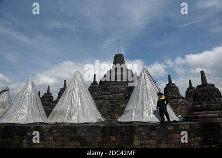 Les agents de conservation du temple de Borobudur enveloppent plusieurs stupas en utilisant la bâche. L'emballage a été effectué au 8ème étage et dans le 1er hall du temple situé à Magelang Central Java, Indonésie. L'augmentation du statut du Mont Merapi à alerte ou niveau 3 (de 4 niveaux existants) a fait que le Borobudur Temple conservation Hall anticipe l'éruption de la montagne la plus active du monde. Indonésie, le 12 novembre 2020. Magelang, Indonésie. Banque D'Images