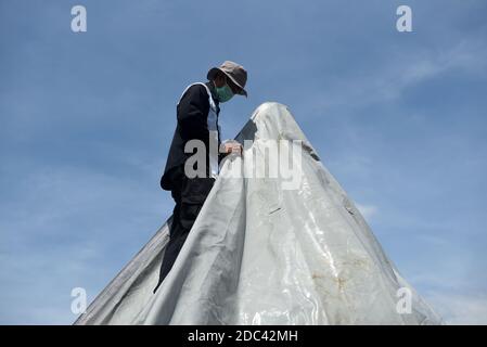 Les agents de conservation du temple de Borobudur enveloppent plusieurs stupas en utilisant la bâche. L'emballage a été effectué au 8ème étage et dans le 1er hall du temple situé à Magelang Central Java, Indonésie. L'augmentation du statut du Mont Merapi à alerte ou niveau 3 (de 4 niveaux existants) a fait que le Borobudur Temple conservation Hall anticipe l'éruption de la montagne la plus active du monde. Indonésie, le 12 novembre 2020. Magelang, Indonésie. Banque D'Images