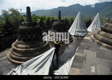 Les agents de conservation du temple de Borobudur enveloppent plusieurs stupas en utilisant la bâche. L'emballage a été effectué au 8ème étage et dans le 1er hall du temple situé à Magelang Central Java, Indonésie. L'augmentation du statut du Mont Merapi à alerte ou niveau 3 (de 4 niveaux existants) a fait que le Borobudur Temple conservation Hall anticipe l'éruption de la montagne la plus active du monde. Indonésie, le 12 novembre 2020. Magelang, Indonésie. Banque D'Images