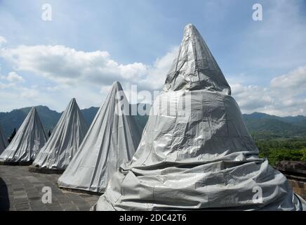 Les agents de conservation du temple de Borobudur enveloppent plusieurs stupas en utilisant la bâche. L'emballage a été effectué au 8ème étage et dans le 1er hall du temple situé à Magelang Central Java, Indonésie. L'augmentation du statut du Mont Merapi à alerte ou niveau 3 (de 4 niveaux existants) a fait que le Borobudur Temple conservation Hall anticipe l'éruption de la montagne la plus active du monde. Indonésie, le 12 novembre 2020. Magelang, Indonésie. Banque D'Images