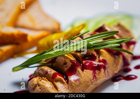 Mousse de foie gras gastronomique aux herbes de romarin servie sur l'assiette Au restaurant pour le dîner. Pâte de canard délicieuse en gros plan Banque D'Images