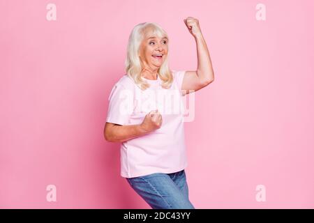 Photo portrait profil de côté de curieux granny gestante comme le gagnant souriant regardant l'espace vierge isolé sur la couleur rose pastel arrière-plan Banque D'Images