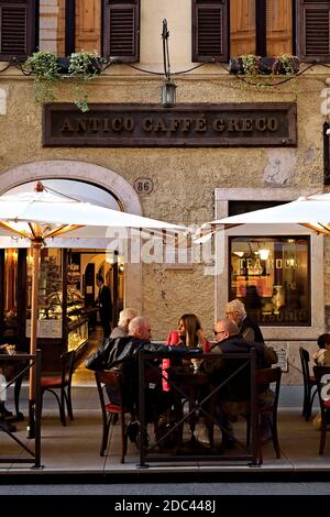 Célèbre Antico Caffè Greco historique. Les gens parlent, assis à des tables à l'extérieur. Les tables sont exceptionnellement en dehors grâce à Covid 19. Rome, Italie, UE. Banque D'Images