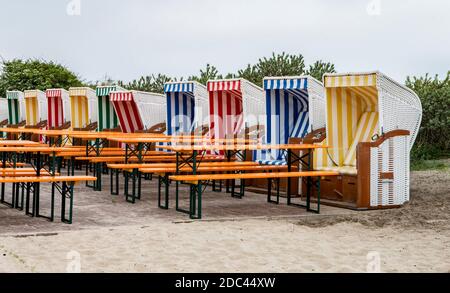 La photo montre plusieurs chaises de plage avec des tables et des bancs Dans un restaurant sur Baltrum Banque D'Images