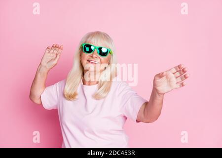 Photo portrait d'une femme âgée dansant isolée sur rose pastel arrière-plan coloré Banque D'Images