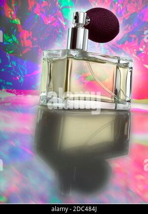 Flacon de parfum en verre avec pulvérisateur à atomiseur. Photographié à un angle bas avec un éclairage spectaculaire, et un arrière-plan psychédélique et coloré. Banque D'Images