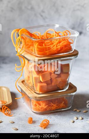 Boîtes en verre avec légumes frais d'orange crus. Citrouille et gros morceaux déchiquetés. Préparation de repas sains, photos de préparation de recettes. Plat végétalien sain Banque D'Images