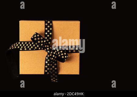 Boîte cadeau ou boîte cadeau avec ruban noir doré arrière-plan noir Banque D'Images