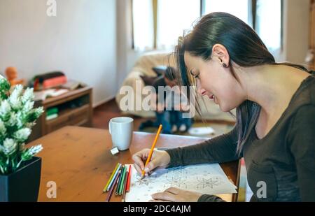 Jeune femme colorant des mandalas Banque D'Images