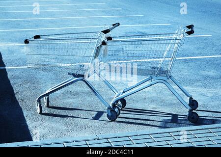 Deux chariots dans le stationnement d'un magasin. Ton bleu Banque D'Images