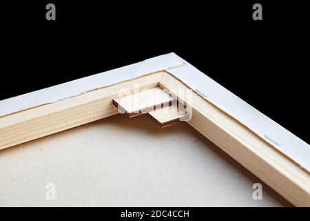 Toile de coton d'art apprêtée étirée sur une civière modulaire en bois avec des coins. Vue arrière. Mise au point sélective. Arrière-plan noir Banque D'Images