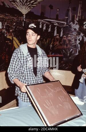 L'acteur Luke Perry de Beverly Hills 90210 à Planet Hollywood à New York, le 4 février 1993, présente ses empreintes et ses autographes dans une bande de ciment. Banque D'Images