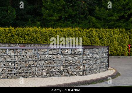 Arrangement de l'espace fait à l'aide d'une clôture en pierres placées dans des paniers en acier. Gabion. Banque D'Images