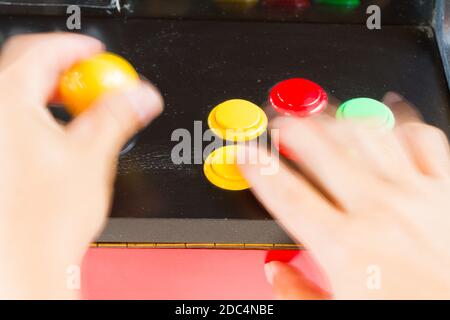 les mains mobiles jouent à un vieux jeu vidéo d'arcade Banque D'Images