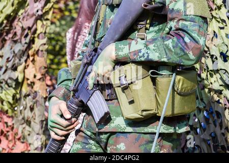 gros plan hommes soldats mains tenant mitrailleuse, focus sélectif sur la main. Banque D'Images