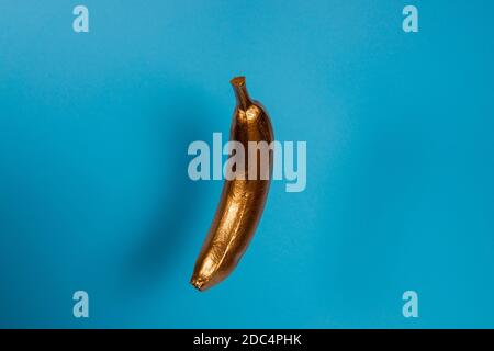 Banane flottante or sur fond bleu. Concept de nourriture minimale Banque D'Images