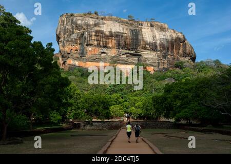 Les touristes traversent les anciens jardins royaux en direction de la forteresse de Sigiriya Rock à Sigiriya au Sri Lanka. Banque D'Images