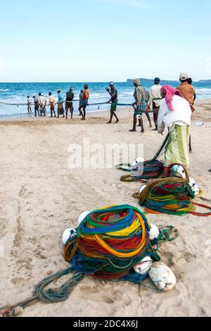 Les pêcheurs de Seine transportent leurs filets de traînée depuis l'océan Indien au large de la plage d'Uppuveli, sur la côte est du Sri Lanka, en fin d'après-midi. Banque D'Images