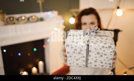 Boîte cadeau de noël blanche entre les mains d'une jeune femme mignonne Banque D'Images
