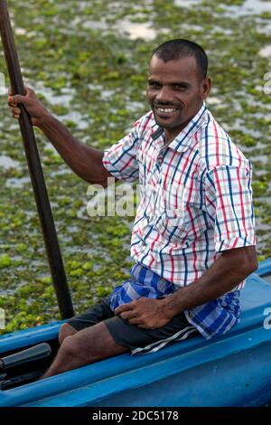 Un pêcheur s'assoit dans son ponton avant de prendre un groupe de touristes pour un voyage sur le lagon de Pottuvil près de Pottuvil sur la côte est du Sri Lanka. Banque D'Images