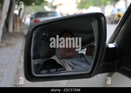 Gaza. 18 novembre 2020. Le palestinien Nayla Abu Jubbah, est assis à son véhicule alors qu'elle travaille à Gaza, le 18 novembre 2020. Nayla, 39 ans, est la première femme chauffeur de taxi dans la bande de Gaza, elle a créé un petit bureau de taxi pour livrer des femmes seulement et l'a appelé 'Al-Mukhtara taxi'. Credit: Rizek Abdeljawad/Xinhua/Alamy Live News Banque D'Images