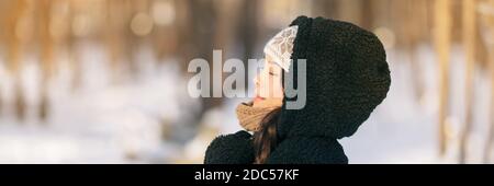 Hiver heureuse femme se relaxant respirer de l'air froid en dehors du mode de vie des jeunes. Fille asiatique avec les yeux fermés respiration bien-être et santé dans la forêt Banque D'Images